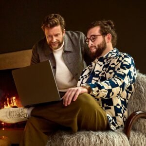 Home 8 Two men looking at a laptop near a fireplace
